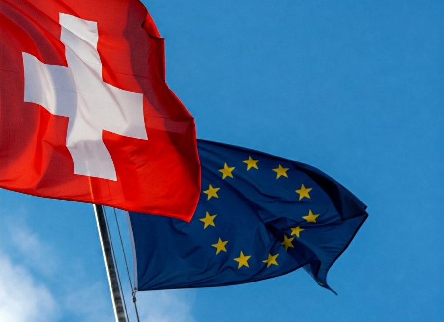 Die Flaggen der Schweiz und der EU wehen nebeneinander im Wind.