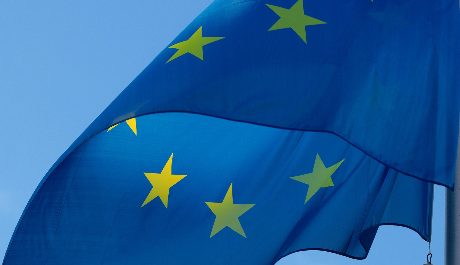 The blue EU flag with its yellow stars waving in the wind